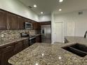 Stylish kitchen showcasing granite countertops, stainless steel appliances, and ample cabinet space at 1208 Castleport Rd, Winter Garden, FL 34787