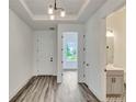 Bright entryway showcasing wood-look floors, modern lighting, and access to various rooms, with a half bath visible at 13075 Sunrise Harvest Dr, Winter Garden, FL 34787