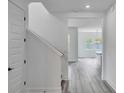 Clean, bright entryway featuring light gray wood-look floors, a staircase, and an open view into the living area at 13075 Sunrise Harvest Dr, Winter Garden, FL 34787