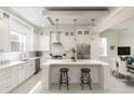 Modern, all-white kitchen with a large island, stainless steel appliances, and stylish pendant lighting at 141 S. Park Ave, Winter Garden, FL 34787