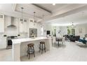 Open-concept kitchen with a breakfast bar, stainless appliances, and seamless flow into the living area at 141 S. Park Ave, Winter Garden, FL 34787