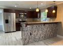 The kitchen features stainless steel appliances, granite countertops, and dark wood cabinets at 1516 Culverhouse Dr, Daytona Beach, FL 32117