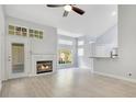 Cozy living room with vaulted ceiling, fireplace, breakfast bar, and light wood-look flooring at 1525 Farrindon Cir, Lake Mary, FL 32746
