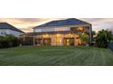 A screened-in backyard featuring solar panels and string lights at 16086 Johns Lake Overlook Dr, Winter Garden, FL 34787