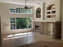 Bright living room with large windows, tile flooring, and fireplace with unique built-in shelving at 2143 Autumn View Dr, Orlando, FL 32825