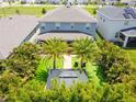 Aerial view of landscaped backyard featuring mature palm trees and a charming outdoor seating area at 2227 Blue Salvia St, Clermont, FL 34711