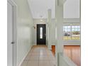 Inviting foyer with tiled flooring, leading to the living areas and featuring a decorative light fixture at 2311 Alton Rd, Deltona, FL 32738