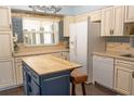 Traditional-style kitchen featuring white cabinets, a blue kitchen island, and modern appliances at 314 Windmeadows St # 314, Altamonte Springs, FL 32701