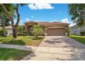 Lovely single-story home with a well-maintained lawn, manicured landscaping, and a two-car garage at 4047 Lillian Hall Ln, Orlando, FL 32812