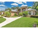 Lovely exterior of a two story home featuring manicured landscaping, an arched entrance, and a grey tile roof at 4052 Gilder Rose Pl, Winter Park, FL 32792
