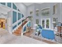 Bright and spacious foyer with a grand staircase, soaring ceilings, and large windows overlooking the backyard at 4052 Gilder Rose Pl, Winter Park, FL 32792