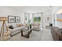 Bright living room featuring neutral furniture, stylish decor, large windows, and an open layout at 4140 Lavender Ct, Lake Hamilton, FL 33851