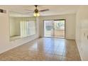 Living room with ceiling fan, mirror wall, and sliding glass doors to outside at 5269 Vineland Rd # 101, Orlando, FL 32811