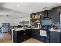 Well-lit kitchen with black cabinets, open shelving, and stainless steel appliances at 631 Warrenton Rd, Winter Park, FL 32792