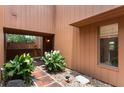 Exterior shot of a brick walkway to a courtyard space with white flowers and views through the house at 105 Oaks Ct, Sanford, FL 32771