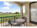 Relaxing balcony with a bistro table, overlooking a lush golf course and beautiful residential neighborhood at 1084 Castle Pines Ct, Reunion, FL 34747