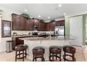 Spacious kitchen featuring dark cabinetry, granite countertops, stainless steel appliances and seating at the kitchen island at 1084 Castle Pines Ct, Reunion, FL 34747