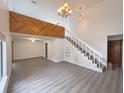 Spacious living room with a vaulted ceiling, wooden beams, staircase, and modern wood-look floors at 1288 Se 32Nd St, Ocala, FL 34471