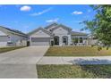 Charming one-story home featuring manicured lawn and a two-car garage at 1821 Benevento St, St Cloud, FL 34771
