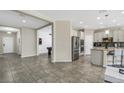 Open kitchen and living area with modern appliances and tile flooring at 1821 Benevento St, St Cloud, FL 34771