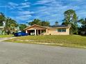 A quaint, single-story home featuring an open carport, solar panels, and neatly kept lawn at 2 Clear Pl, Ocala, FL 34472