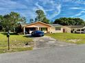 Inviting single-story home with an open carport and driveway, complemented by a green lawn at 2 Clear Pl, Ocala, FL 34472