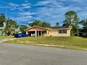 A quaint, single-story home featuring an open carport, solar panels, and neatly kept lawn at 2 Clear Pl, Ocala, FL 34472
