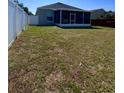 Large backyard featuring a white fence and well-maintained lawn and partially covered lanai at 2049 Crosscreek Ct, Oviedo, FL 32766