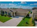 Inviting home with a lush green lawn, an attached garage, and attractive landscaping, offering great curb appeal at 214 Brave Rd, Davenport, FL 33837