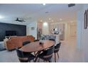 Open-concept living space featuring a modern kitchen with an island, dining area, and a cozy living room with a stylish accent wall at 214 Brave Rd, Davenport, FL 33837
