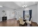 Formal dining area boasts wood floors, chandelier, and a view from the arched window and front door at 2203 Essex Dr, Ocoee, FL 34761