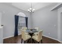 Formal dining area boasts wood floors, chandelier, and a view from the arched window at 2203 Essex Dr, Ocoee, FL 34761