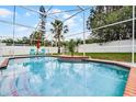 Close-up of a sparkling pool with brick trim, set in a screened enclosure and ready for summer fun at 2203 Essex Dr, Ocoee, FL 34761