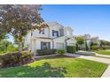 Inviting two-story townhome with a well-kept lawn, mature tree, and an attached two-car garage at 2488 Hassonite St, Kissimmee, FL 34744