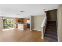 Open-concept living area with wood flooring, staircase, and sliding glass doors to outdoor space at 2488 Hassonite St, Kissimmee, FL 34744