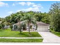 Inviting single-story home with a manicured lawn, mature palm tree, and a convenient two-car garage at 2888 Middleton Cir, Kissimmee, FL 34743