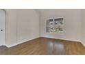 Clean bedroom with wood floors, neutral walls, and a window view to the backyard at 3014 Linmont Ln, Eustis, FL 32726