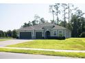 Charming single-story home with lush lawn, three car garage, and mature trees at 5161 Kingwell Cir, Oviedo, FL 32765