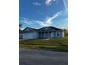 Charming single-story home with a two-car garage, manicured lawn, and covered entryway, set against a bright blue sky at 567 Viceroy Ct, Kissimmee, FL 34758