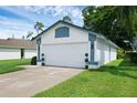 Charming single-story home features a two-car garage, landscaped yard, and freshly painted white and blue exterior at 5729 Norman H Cutson Dr, Orlando, FL 32821