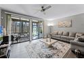 Spacious living room with tile floors, stylish rug, and sliding glass doors to the outside patio at 658 Lake Villas Dr, Altamonte Springs, FL 32701
