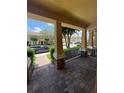 Inviting covered front porch with brick columns and a view of the neighborhood street at 7629 Ripplepointe Way, Windermere, FL 34786