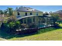 Back of the home featuring an enclosed pool and hot tub in a well-maintained yard at 8520 La Isla Dr, Kissimmee, FL 34747