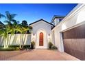 Inviting arched entryway with a wooden door, lanterns, and decorative potted plants at 9743 Covent Garden Dr, Orlando, FL 32827