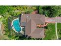 Aerial shot showcases the home's roof, screened pool, and lush surroundings in a serene setting at 102 Ichabod Trl, Longwood, FL 32750