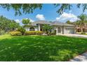 Charming single-story home featuring a well-manicured lawn, beautiful landscaping, and a two-car garage at 13108 Lakeshore Grove Dr, Winter Garden, FL 34787