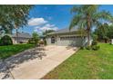 Single-story home featuring a well-manicured lawn, beautiful landscaping, and a two-car garage at 13108 Lakeshore Grove Dr, Winter Garden, FL 34787