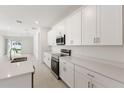Modern kitchen featuring white cabinets, stainless steel appliances, and quartz countertops at 150 Fredericksburg Ave, Orange City, FL 32763