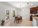 Cozy dining area with natural light, modern light fixture, and easy access to the outdoor patio at 15058 Sawgrass Bluff Dr, Winter Garden, FL 34787