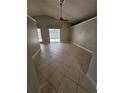 Spacious living room with tile flooring, leading to a screened-in pool area at 1710 Canoe Creek Rd, Oviedo, FL 32766